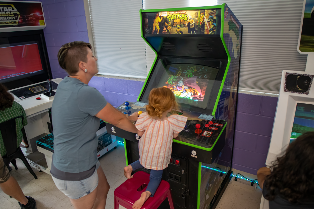 Picture of mother and daughter playing Teenage Mutant Ninja Turtle arcade game at 6R's entertainment yard
